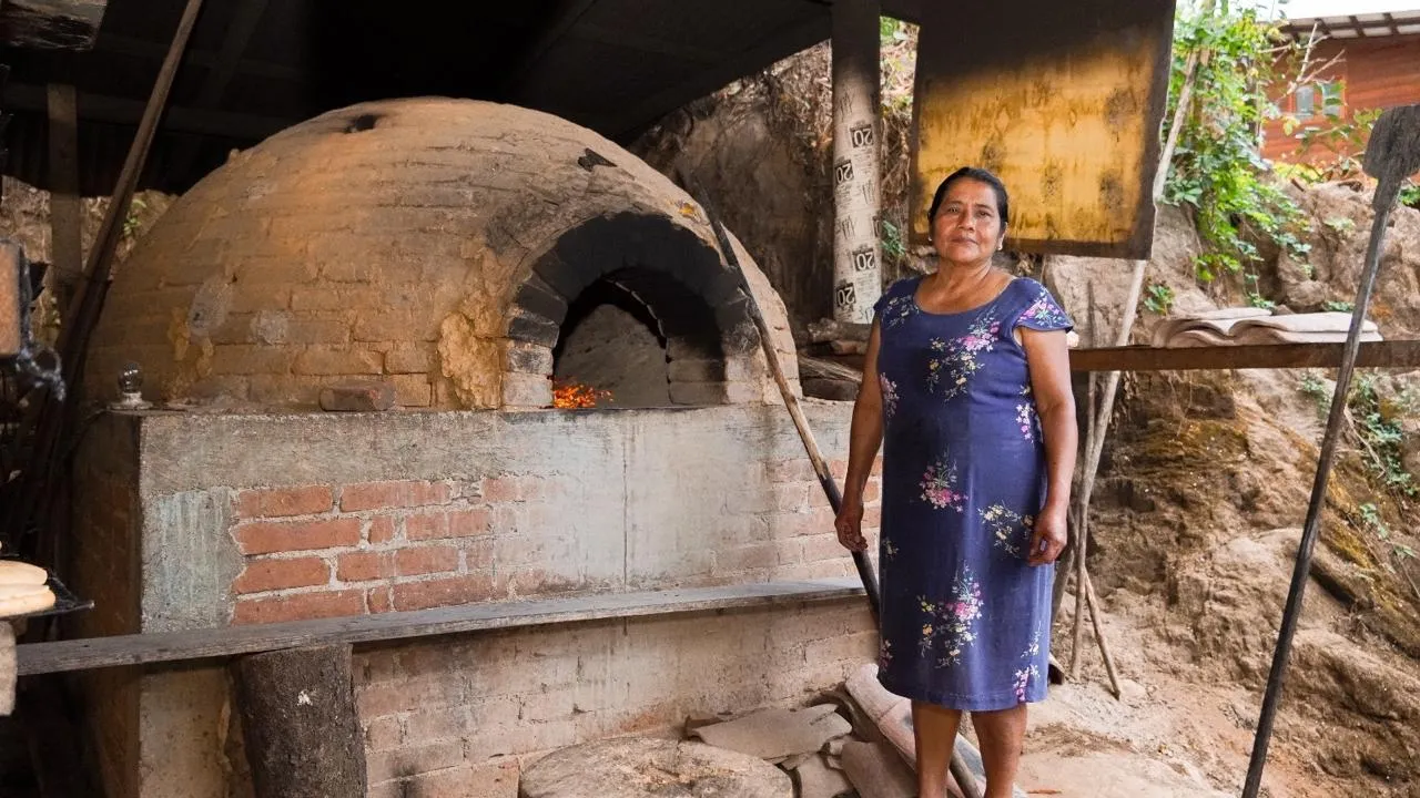 Mujer panadera frente a un horno de barro tradicional en Juquila